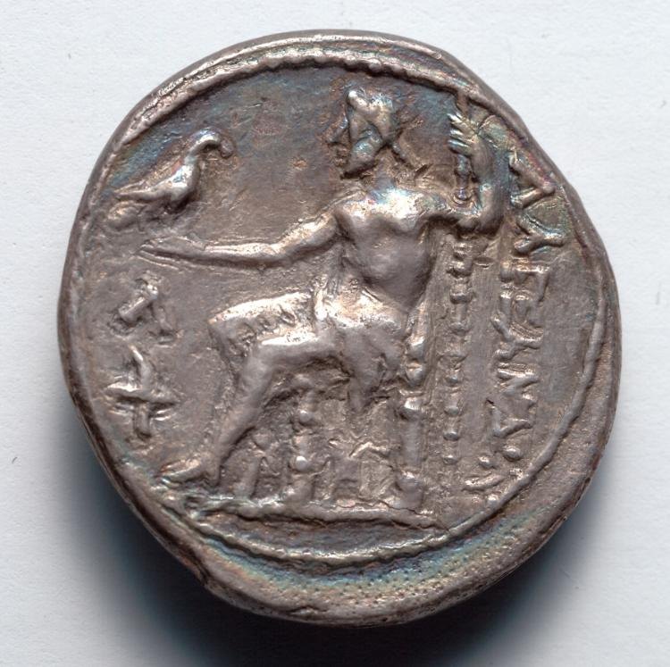 A worn silver coin with seated Zeus holding a staff and eagle.