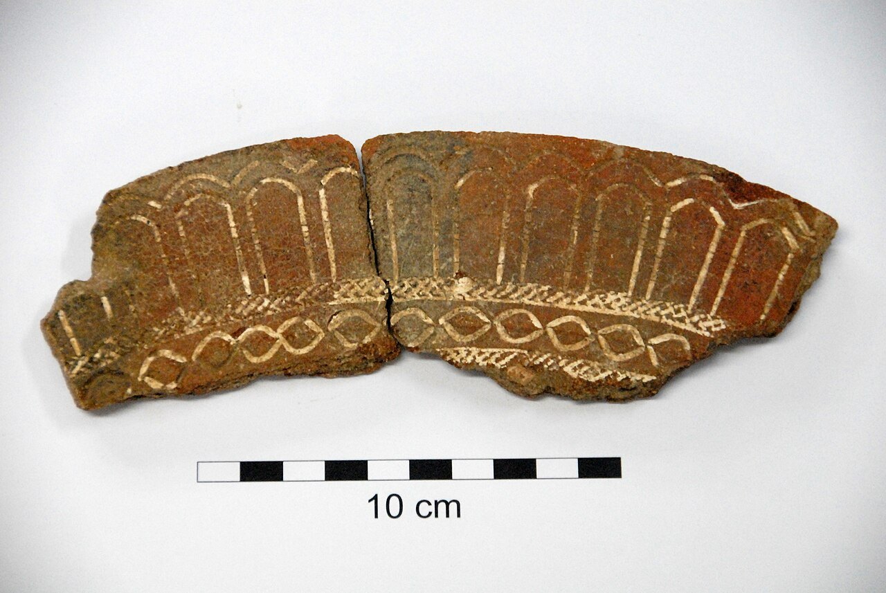 A small pottery rim sherd with stamped geometric decoration.