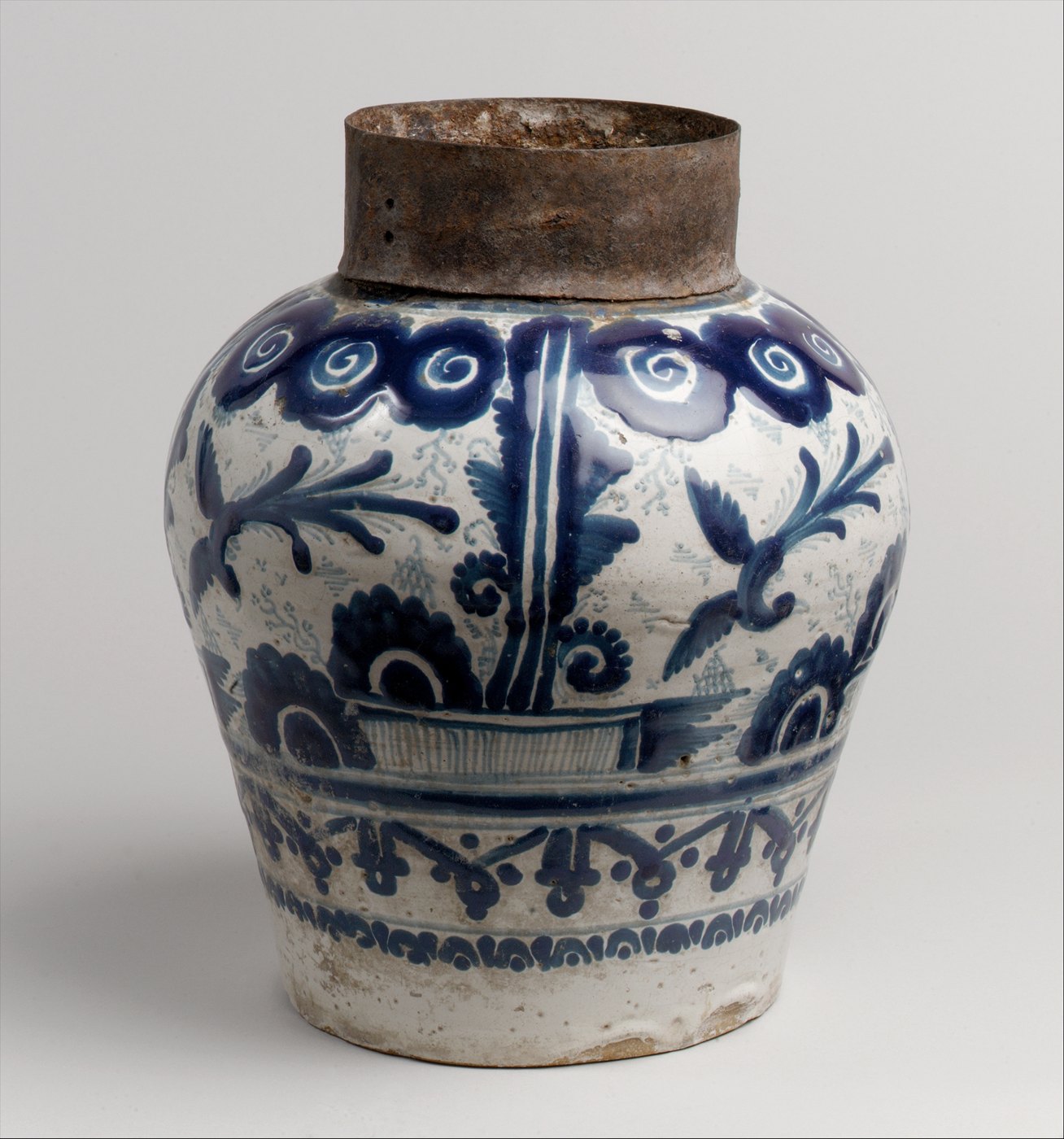 A blue-and-white decorated ceramic chocolate jar with a dark neck fitting.