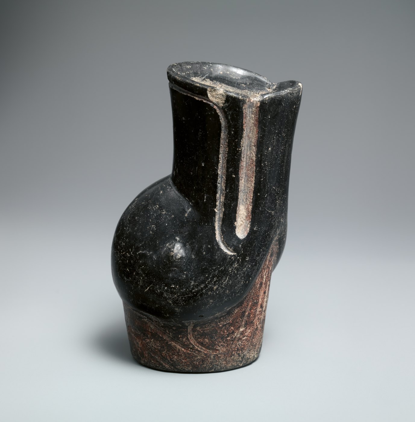 A ceramic vessel shaped with a rounded duck head and beak.