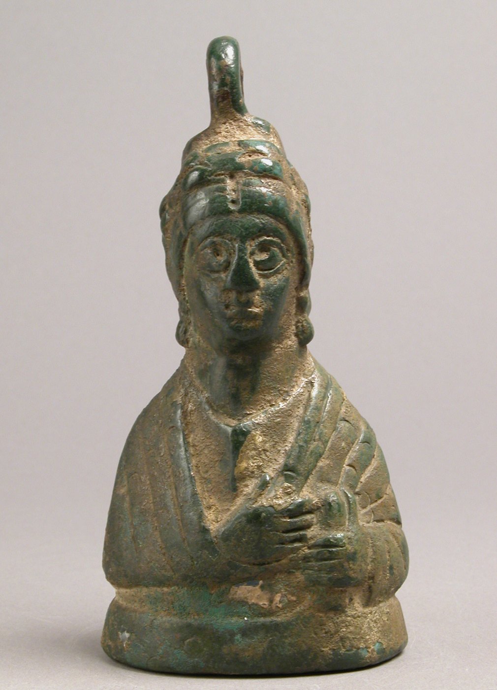 A bronze bust of a crowned woman used as a weight.