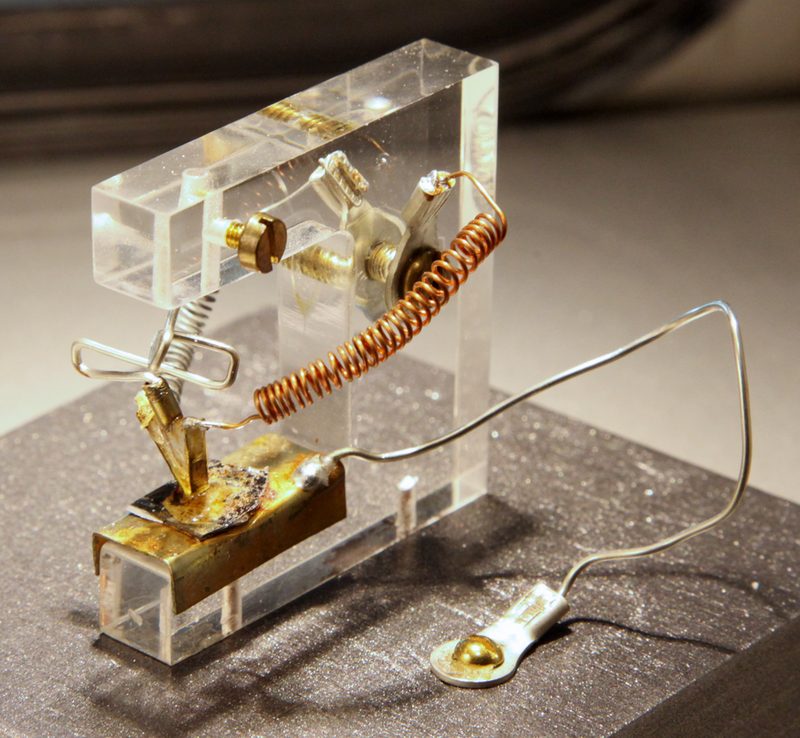 Réplica de transistor con hilos finos y contactos metálicos sobre soporte transparente