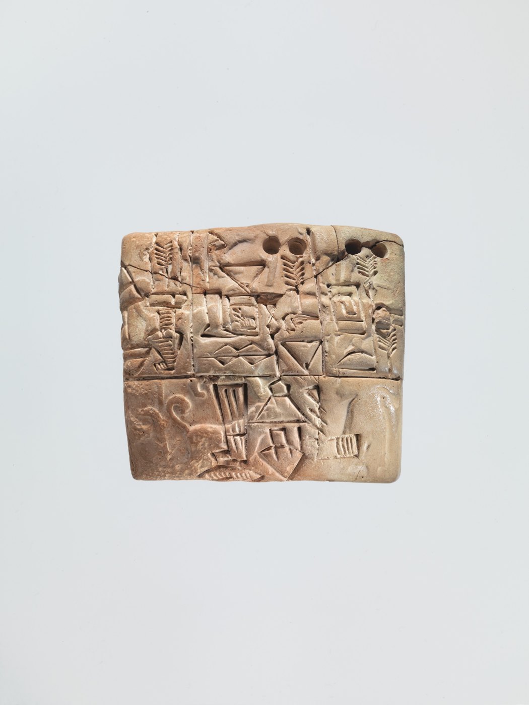 A clay tablet covered with early signs and a seal impression.