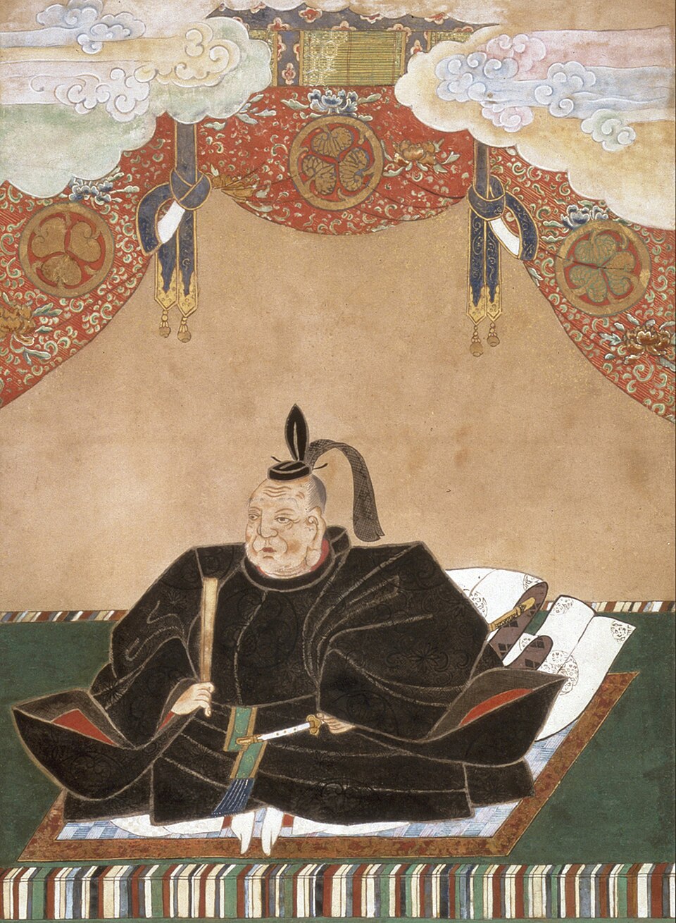 검은 예복과 관을 착용하고 앉은 이에야스. 뒤쪽 휘장에는 도쿠가와 가문의 아오이 문장이 그려져 있습니다.